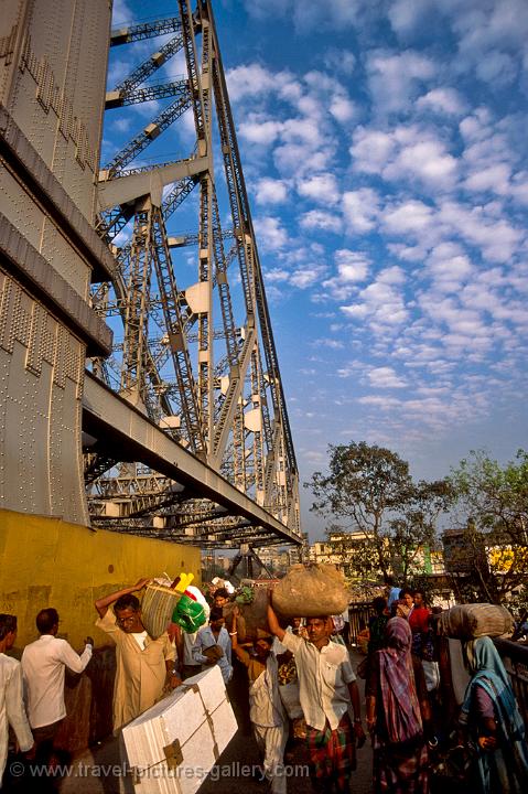 people crossing Howrah Bridge over the Hooghly River
