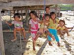 local kids underneath a stilt house