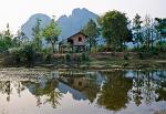house and mountains reflecting in a pond