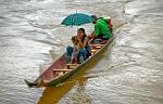 woman and child crossing the river by long tail boat