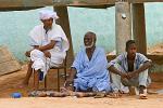 men relaxing on the side of the street