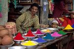 man selling color dyes at the market