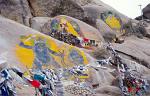Buddhist paintings and prayer flags on a rock