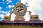 the Dharma Wheel and deer symbolise the Buddha's first sermon