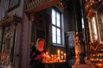 Odessa, woman burning a canle in an orthodox church