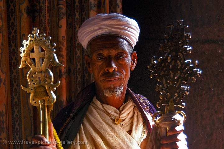 a priest holding crosses in one of Lalibela's rock hewn churches