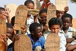 Quran lessons, boys writing texts on planks